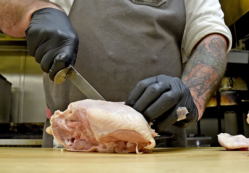 Bald Headed Bistro chef Eric Fulkerson uses his favorite boning knife to carve a chicken on May 14, 2017, in Cleveland, Tenn.