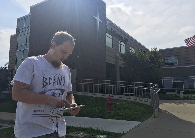 
              In this July 14 2017 photo, Jonathan Nickell checks his iPad while waiting for his wife to have surgery at the St. Joseph Mount Sterling hospital in Mount Sterling, Ky. Nickell said rural hospitals are essential to their community. Many rural hospitals have struggled financially because they serve large populations of poor people who don't have insurance. (AP Photo/Adam Beam)
            