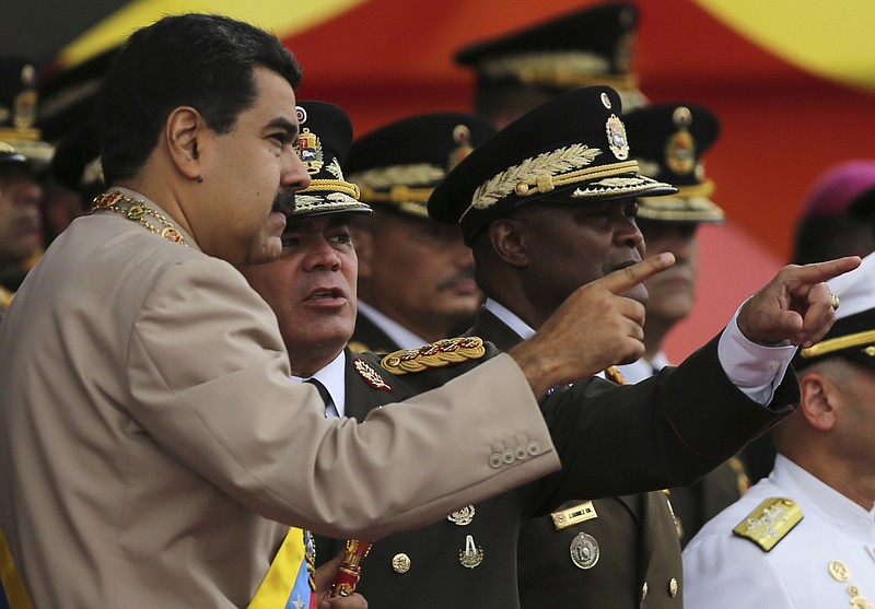
              FILE - In this June 24, 2017 file photo, Venezuela's President Nicolas Maduro, left, talks to his Defense Minister Vladimir Padrino Lopez during Army Day celebrations at Fuerte Tiuna, in Caracas, Venezuela. Padrino Lopez challenged on Wednesday, July 19, 2017 the countries that have declared against the government's initiative to rewrite Venezuela's constitution, saying the nation will not submit to foreign governments. (AP Photo/Fernando Llano, File)
            