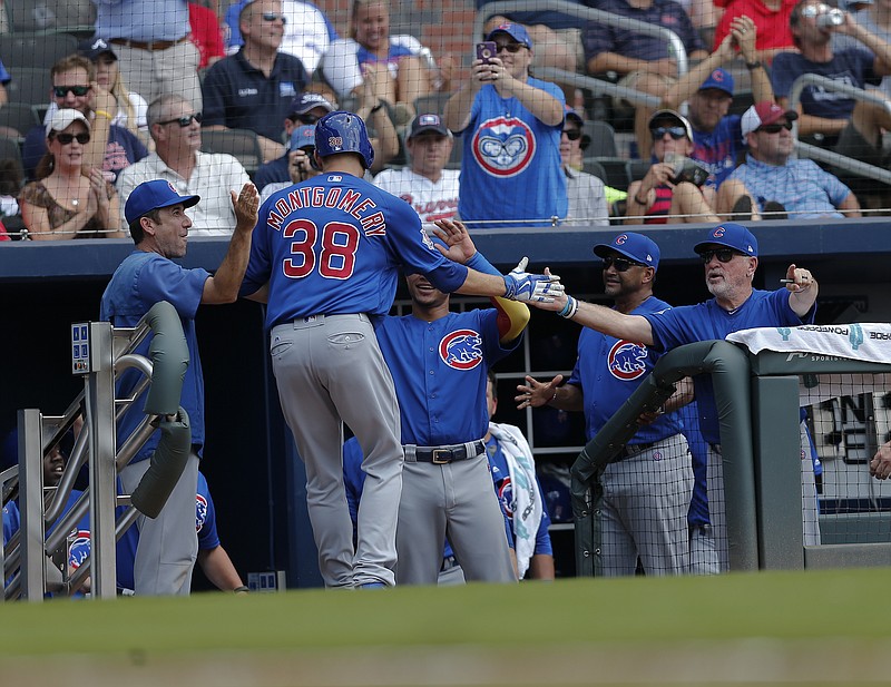 
              Chicago Cubs pitcher Mike Montgomery (38) is greeted at the dugout by teammates including manager Joe Maddon, right, after hitting a home run in the fifth inning of a baseball game against the Atlanta Braves, Wednesday, July 19, 2017, in Atlanta. (AP Photo/John Bazemore)
            