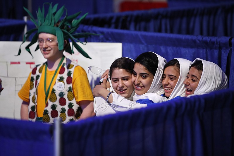 
              Team Afghanistan, from second from left, Kawsar Rashan, Lida Azizi, Somayeh Faruqi, and Rodaba Noori, next to a member of Team Australia, left, hug before their final round of competition at the FIRST Global Robotics Challenge, Tuesday, July 18, 2017, in Washington. The challenge is an international robotics event with teams from over 100 countries. (AP Photo/Jacquelyn Martin)
            