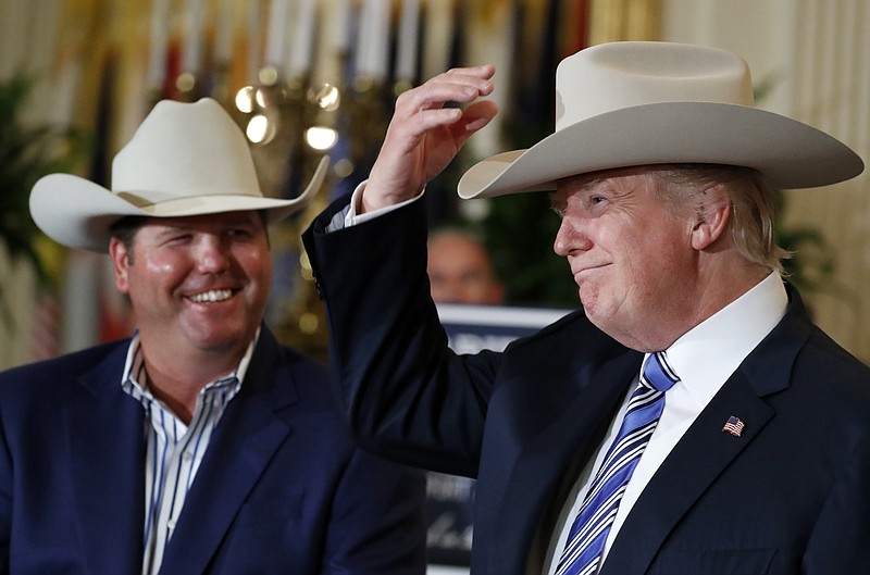 
              In this July 17, 2017, photo, President Donald Trump tries on a Stetson hat, as Dustin Noblitt, with Stetson Hats, smiles, during a "Made in America," product showcase featuring items created in each of the U.S. 50 states, at the White House in Washington. Stetson is base in Garland, Texas. Trump’s latest effort to change the subject pulled out all the stops _ and props. (AP Photo/Alex Brandon)
            