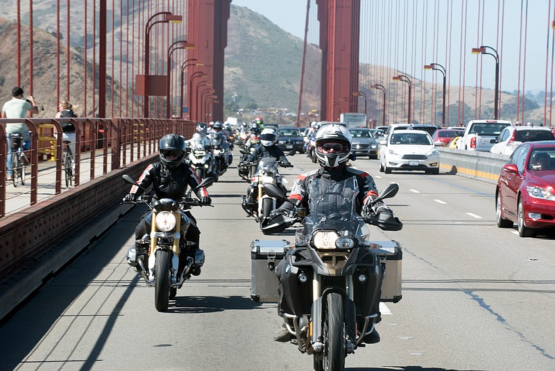 In this July 2016 photo provided by Alisa Clickenger, Clickenger leads a group of women riders over the Golden Gate Bridge in San Francisco at the end of a cross-country trip to honor two sisters from Brooklyn, N.Y., who made a similar ride in 1916. Clickenger operates Women's Motorcycle Tours, which conducts motorcycle rides that cater exclusively to women, and estimates she's traveled more than 250,000 miles on motorcycles. (Christina Shook/Courtesy of Alisa Clickenger via AP)