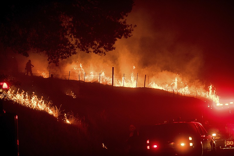 Flames from a backfire burn as CalFire crews battle a wildfire near Mariposa, Calif., Tuesday, July 18, 2017. Record rain and snowfall in the mountains this winter was celebrated for bringing California's five-year drought to its knees, but it has turned into a challenge for firefighters battling flames feeding on dense vegetation, officials said. (AP Photo/Noah Berger)