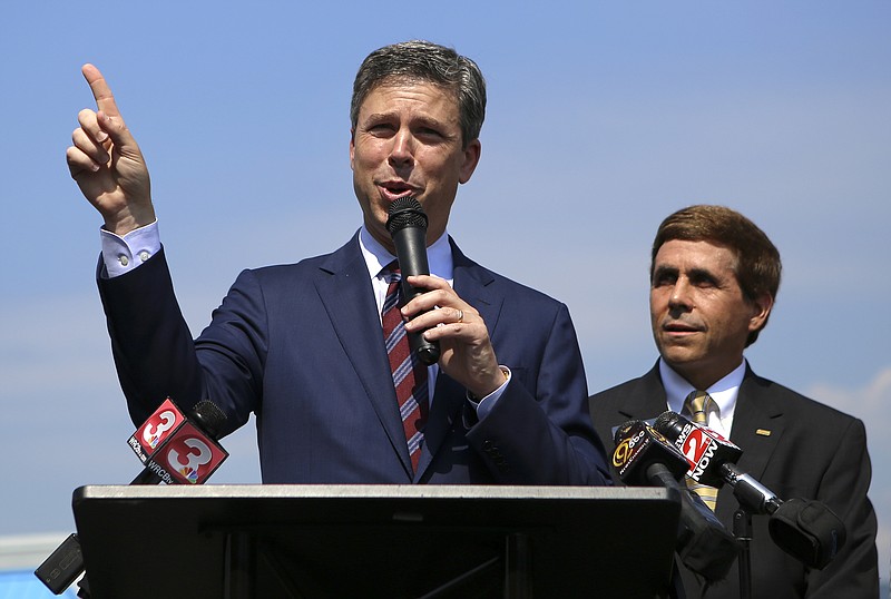 Chattanooga Mayor Andy Berke, left, announces the city will acquire the right-of-ways to a private portion of Northpoint Boulevard and spend $500,000-$600,000 to repair the bumpy, potholed street.