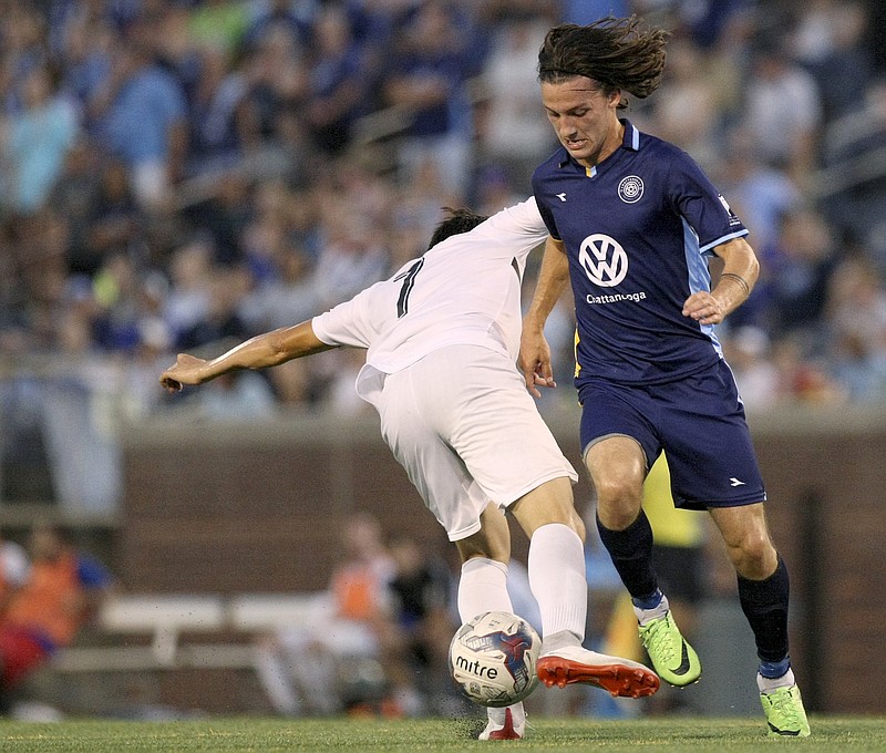 Chattanooga FC midfielder Cameron Woodfin (29) maneuvers the ball past Inter Nashville FC midfielder Jose Alberto Castellanos Cordova (7) during the second half of a play-in match for the NPSL Southeast Conference semifinals at Finley Stadium on Tuesday, July 11, in Chattanooga, Tenn.