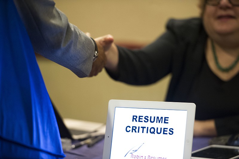 
              FILE - In this Thursday, May 30, 2013, file photo, a job seeker stops at a table offering resume critiques during a job fair held in Atlanta. On Friday, July 21, 2017, the Labor Department reports on state unemployment rates for June. (AP Photo/John Amis, File)
            