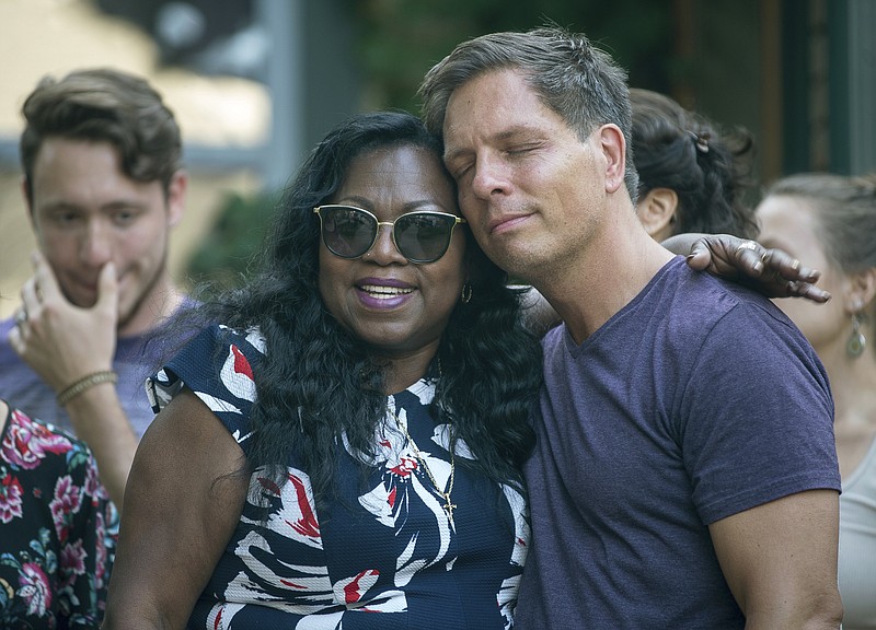 
              Don Damond, the fiance of Justine Damond, is comforted outside his home by Valerie Castile, the mother of Philando Castile, as demonstrators march by Damond's home during a march in honor of Justine Damond, Thursday, July 20, 2017, in Minneapolis. Both Philando Castile and Justine Damond were shot and killed by Minneapolis police officers. (Aaron Lavinsky /Star Tribune via AP)
            