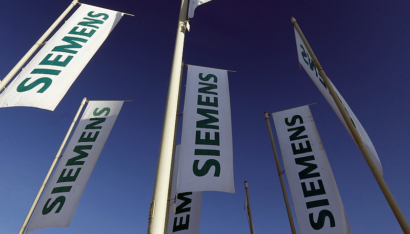 
              FILE - In this Jan. 23, 2013 file photo flags of German engineering conglomerate Siemens AG fly during an annual shareholder meeting in Munich, southern Germany. German industrial conglomerate Siemens AG says Friday, July 21, 2017 it’s halting deliveries of power generation equipment to state-controlled companies in Russia and selling its stake in a Russian company that offers services for power plant control systems. (AP Photo/Matthias Schrader, File)
            