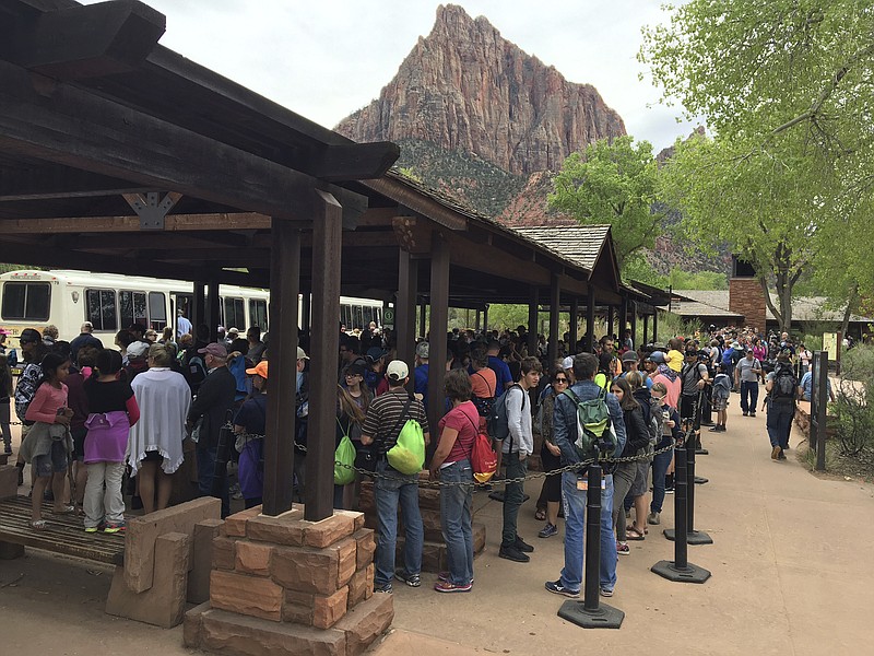 
              In this Nov. 2016, photo provided by Zion National Park, people line up at Zion National Park, in Utah. The sweeping red-rock vistas at Zion National Park are increasingly filled with a bumper crop of visitors, and now park managers are weighing an unusual step to stem the tide: : Requiring tourists to make RSVPs to get in.  (Zion National Park via AP)
            