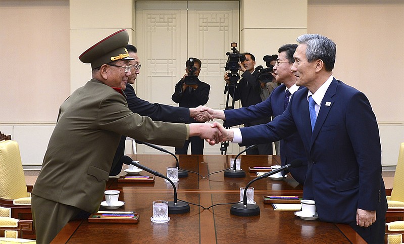 
              FILE - In this Aug. 22, 2015 file photo provided by the South Korean Unification Ministry, South Korean National Security Director, Kim Kwan-jin, right, and Unification Minister Hong Yong-pyo, second from right, shake hands with Hwang Pyong So, left, North Korea' top political officer for the Korean People's Army, and Kim Yang Gon, a senior North Korean official responsible for South Korean affairs, during their meeting at the border village of Panmunjom in Paju, South Korea. ISouth Korea has urged North Korea to accept its offers for talks as Pyongyang continues to ignore Seoul's proposal for a military meeting to ease animosities along their tense border. (The South Korean Unification Ministry via AP, File)
            