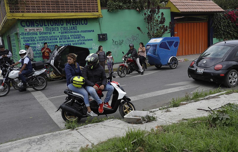 
              Residents and motorcycle taxi drivers stop to look at marines blocking the area where a suspected drug gang leader and seven others were killed in a shootout in the Tlahuac district of Mexico City, Thursday, July 20, 2017. Mexico City residents were stunned by the sight of drug-war-style violence, including burnt-out vehicles and road blockades by gang-sympathizing motorcycle taxi drivers, in the nation's capital, sights that had previously been seen only in violence-wracked cities like Reynosa and Nuevo Laredo.(AP Photo/Rebecca Blackwell)
            