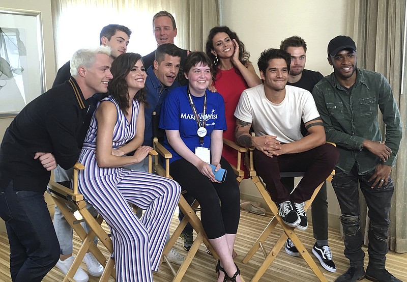 
              Sydney Lang, 16, of Edmonton, Alberta, seated center, poses with cast members from "Teen Wolf" during a meet-and-greet arranged by the Make-A-Wish Foundation on day two of Comic-Con International on Friday, July 21, 2017, in San Diego. Pictured from front row left, Colton Haynes, Shelley Hennig, Charlie Carver, Tyler Posey and Khylin Rhambo, and from back row left are Cody Christian, Linden Ashby, Melissa Ponzio, and Dylan Sprayberry. (AP Photo/Sandy Cohen)
            
