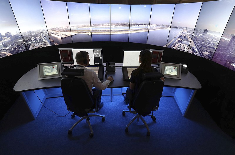 
              FILE - This is a May 19, 2017  file photo of National Air Traffic Services personnel giving a demonstration in the operations room at National Air Traffic Services in Swanwick southern England. Britain is poised to handle a record number of flights in its increasingly crowded skies. The NATS air traffic control agency said it expects to handle some 8,800 flights Friday, in what is expected to be the peak day of the busy summer travel season. (Andrew Matthews/PA File via AP)
            