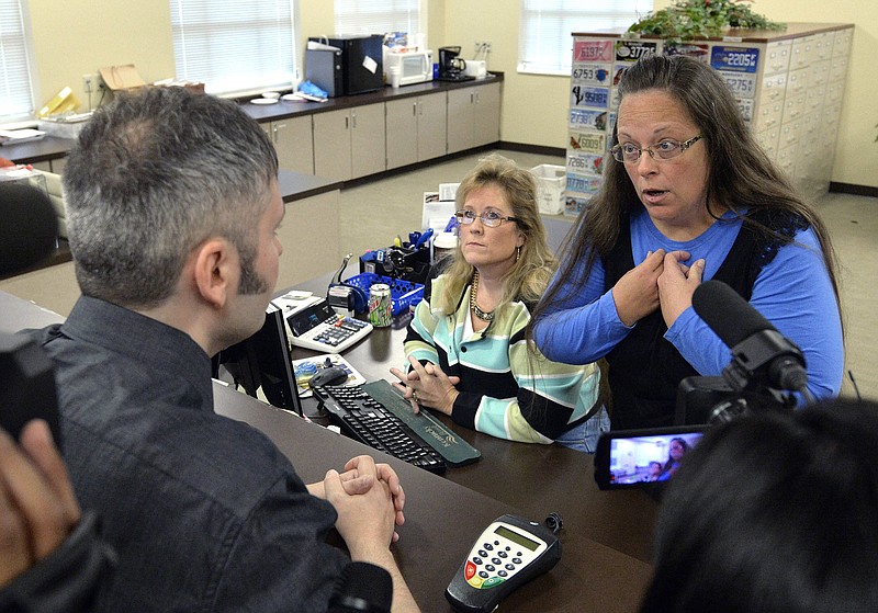 
              FILE - In this Sept. 1, 2015, file photo, Rowan County Clerk Kim Davis, right, talks with David Moore following her office's refusal to issue marriage licenses at the Rowan County Courthouse in Morehead, Ky. On Friday, July 21, 2017, a federal judge has ordered Kentucky taxpayers to pay more than $220,000 in attorneys' fees for the elected county clerk who caused a national uproar by refusing to issue marriage licenses to same-sex couples. (AP Photo/Timothy D. Easley, File)
            