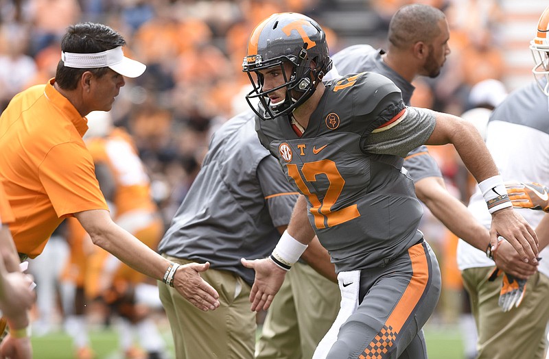 Quarterback coach Mike Canales greets quarterback Quinten Dormady (12).  The annual Spring Orange and White Football game was held at Neyland Stadium on April 22, 2017.