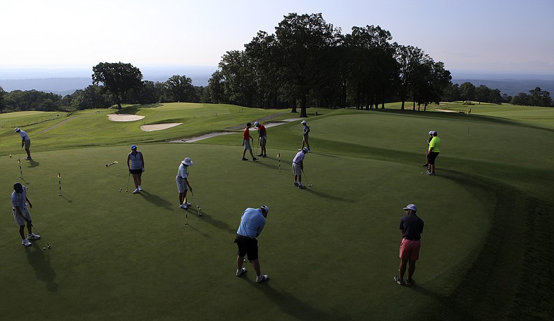 Golfers warm up on the putting green at the Lookout Mountain Club on Monday, July 17, in Lookout Mountain, Ga.