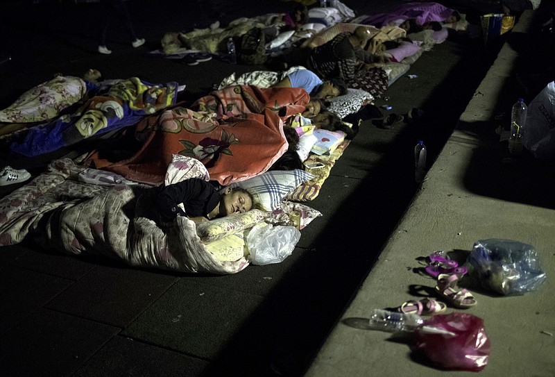 
              People sleep at a playground early Saturday, July 22, 2017 following an earthquake in the Mediterranean island of Kos, Greece. Causing panic but little serious damage, a powerful earthquake shook Friday vacation resorts in Greece and Turkey, hurting nearly 500 people and killing two tourists who were crushed when a building collapsed on a popular bar in the Greek island of Kos.(AP Photo/Petros Giannakouris)
            