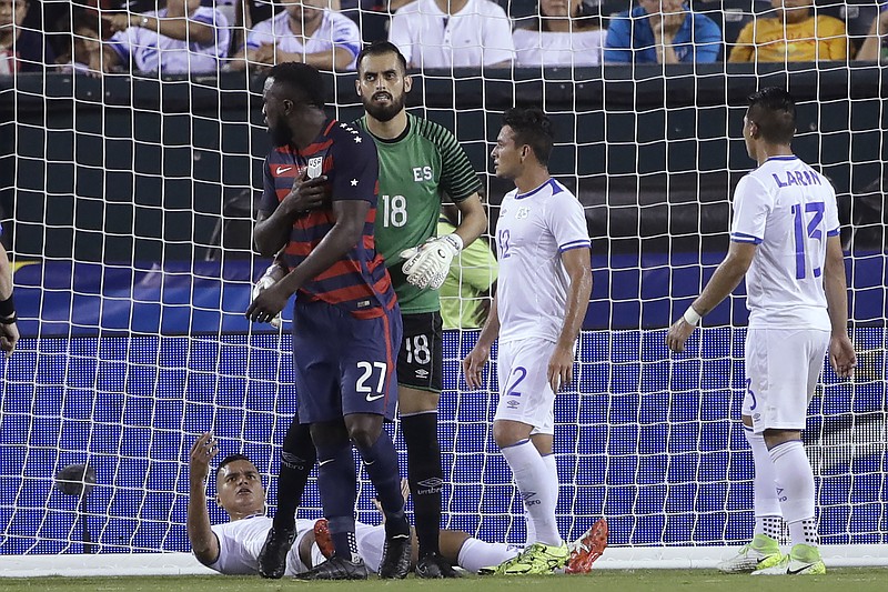 
              El Salvador's Derby Carrillo (18) holds Unites States' Jozy Altidore (27) as he reacts to an incident with El Salvador's Henry Romero, lying on the ground, during a CONCACAF Gold Cup quarterfinal soccer match in Philadelphia, Wednesday, July 19, 2017. Romero appeared to first bite Altidore on the back of a shoulder and then pull the American forward's nipple. Canadian referee Drew Fischer, a Major League Soccer regular, did not penalize the incident. (AP Photo/Matt Rourke)
            