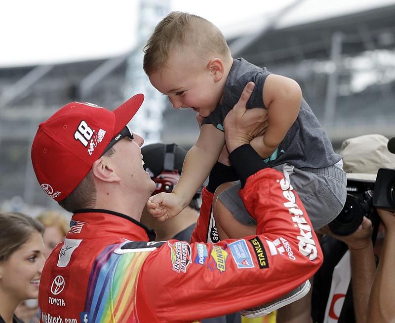 
              Kyle Busch talks with his son, Brexton, after winning the pole for the NASCAR Cup auto race at Indianapolis Motor Speedway, in Indianapolis on Saturday, July 22, 2017. (AP Photo/Darron Cummings)
            