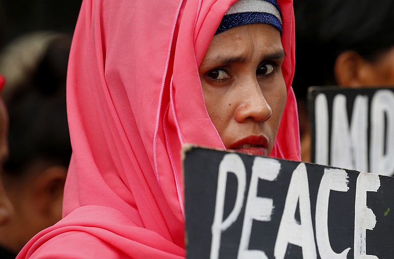 
              A protester displays a placard during a rally outside the Lower House as lawmakers gather for a special joint session on the possible extension of martial law in the southern Philippines, Saturday, July 22, 2017 in Quezon city, northeast of Manila, Philippines. Martial Law was declared by President Duterte last May 23 for 60 days following the siege by Muslim militants of Marawi city which is now on its second month. (AP Photo/Bullit Marquez)
            