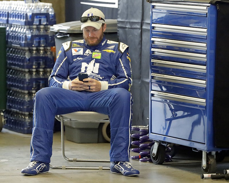 
              Race driver driver Dale Earnhardt Jr. looks at his phone before a practice session for the NASCAR auto race at Indianapolis Motor Speedway, in Indianapolis Saturday, July 22, 2017. (AP Photo/Darron Cummings)
            