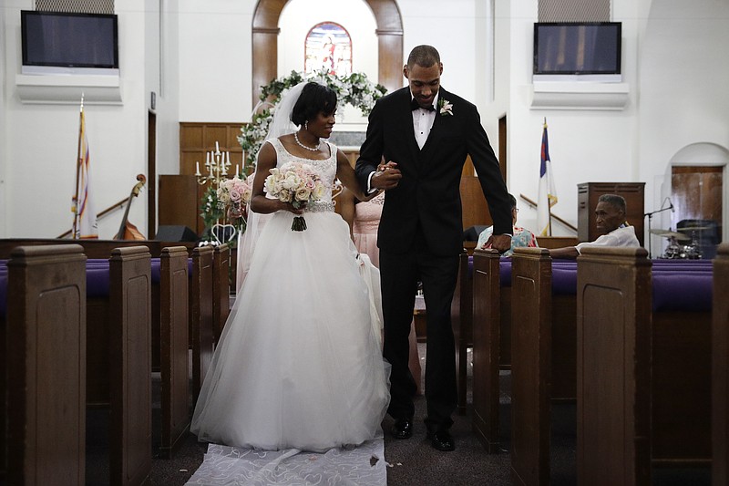 
              Two-time Olympic jumper Jamie Nieto, right, who was paralyzed from neck down 15 months ago after a spinal cord injury, pauses for a moment while walking down the aisle with his bride Shevon Stoddart after their wedding ceremony Saturday, July 22, 2017, in El Cajon, Calif. Step by halting step, Nieto made good on his vow to walk his new wife down the aisle of the church and out the door to a waiting limousine. (AP Photo/Jae C. Hong)
            