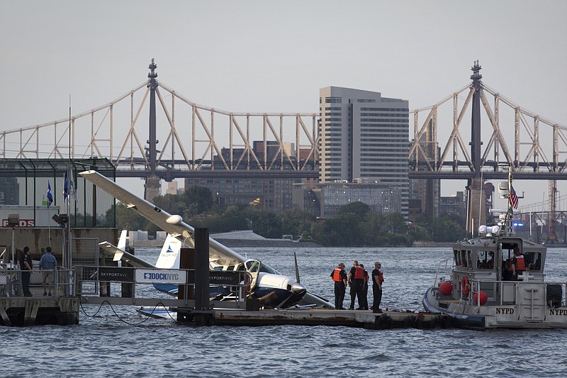 
              Emergency responders attend to a seaplane that made a hard landing during a failed takeoff along the FDR Drive on Friday, July 21, 2017, in New York. (AP Photo/Kevin Hagen)
            