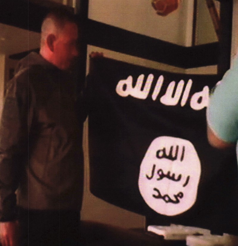 
              FILE - In this July 8, 2017 file image taken from FBI video and provided by the U.S. Attorney's Office in Hawaii on July 13, 2017, Army Sgt. 1st Class Ikaika Kang holds an Islamic State group flag after allegedly pledging allegiance to the terror group at a house in Honolulu. A federal grand jury in Hawaii has indicted Kang for attempting to provide material support to the Islamic State group. Kang was indicted Friday, July 21 after he was arrested by an FBI SWAT team on July 8. Kang was ordered held without bail. Because of the indictment, Kang will no longer have a preliminary hearing that was scheduled for Monday, July 24. (FBI/U.S Attorney's Office, District of Hawaii via AP, File)
            