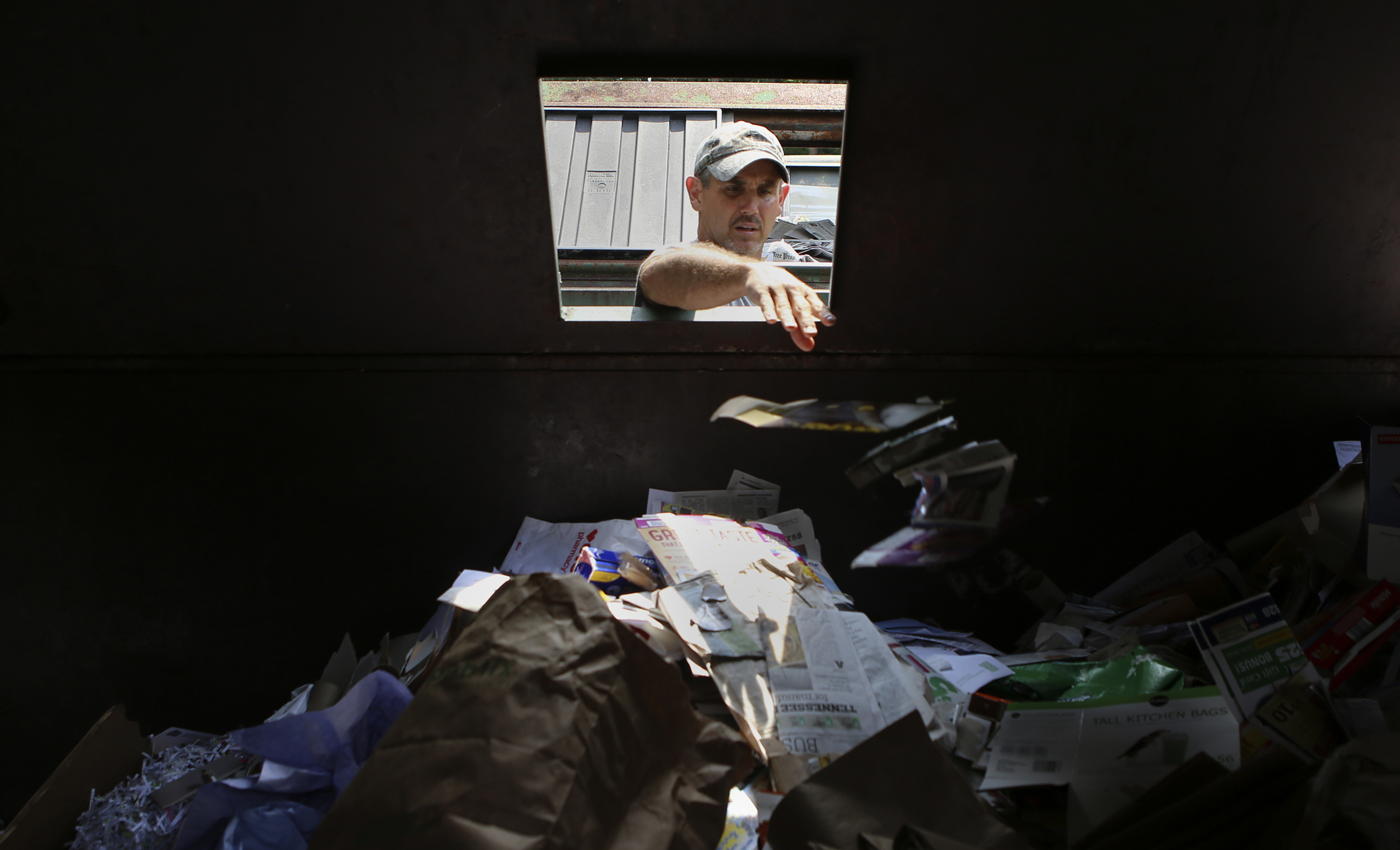 Ben Duvall, of Sale Creek, tosses away some items to be recycled at the Sequoyah Recycling Center on Thursday, July 20, in Soddy-Daisy, Tenn. The Sequoyah Transfer Station located next to the county-run recycling center is closing permanently, however, the recycling center will stay open.