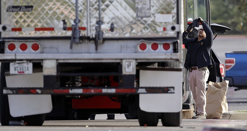 
              Evidence is collected at the scene where eight people were found dead in a tractor-trailer loaded with multiple others, outside a Walmart store in stifling summer heat in what police are calling a horrific human trafficking case, Sunday, July 23, 2017, in San Antonio. (AP Photo/Eric Gay)
            