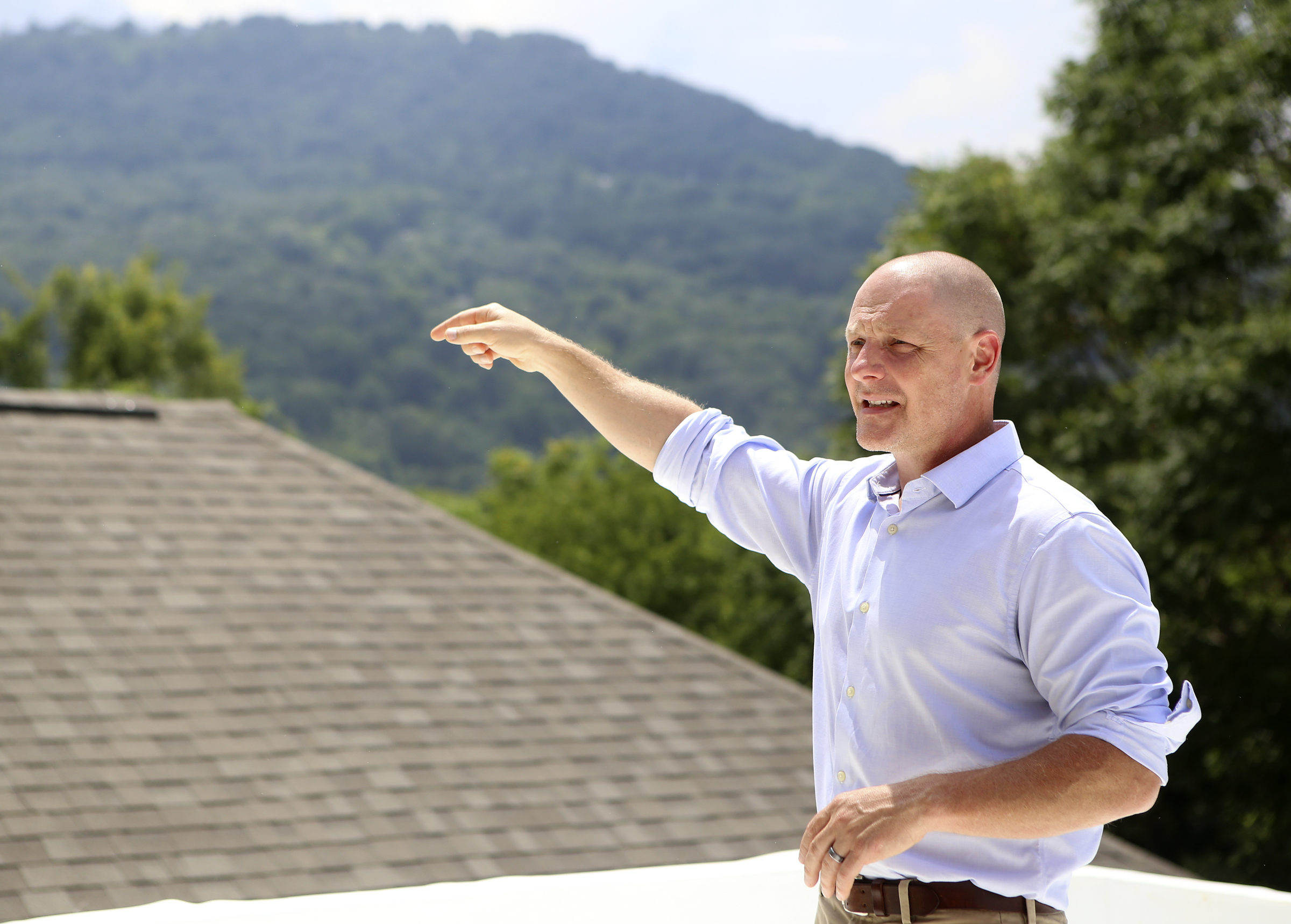 Ethan Collier gives a tour of the rooftop space of one of the homes under construction at the new housing development One Hundred at South Broad on Wednesday, July 12, in Chattanooga, Tenn.
