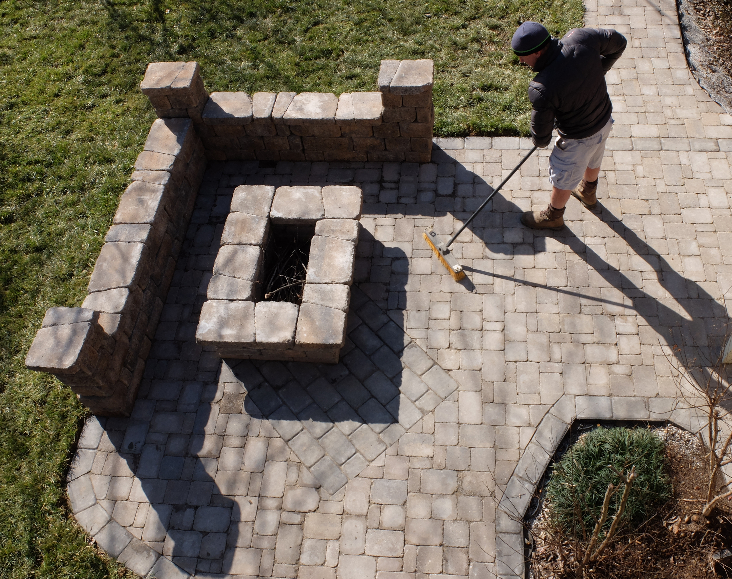 Michael T. Castle, of thelawnsharks.com, sweeps an area after laying Belgard pavers and building a fire pit at this Forest Plaza home in Hixson.