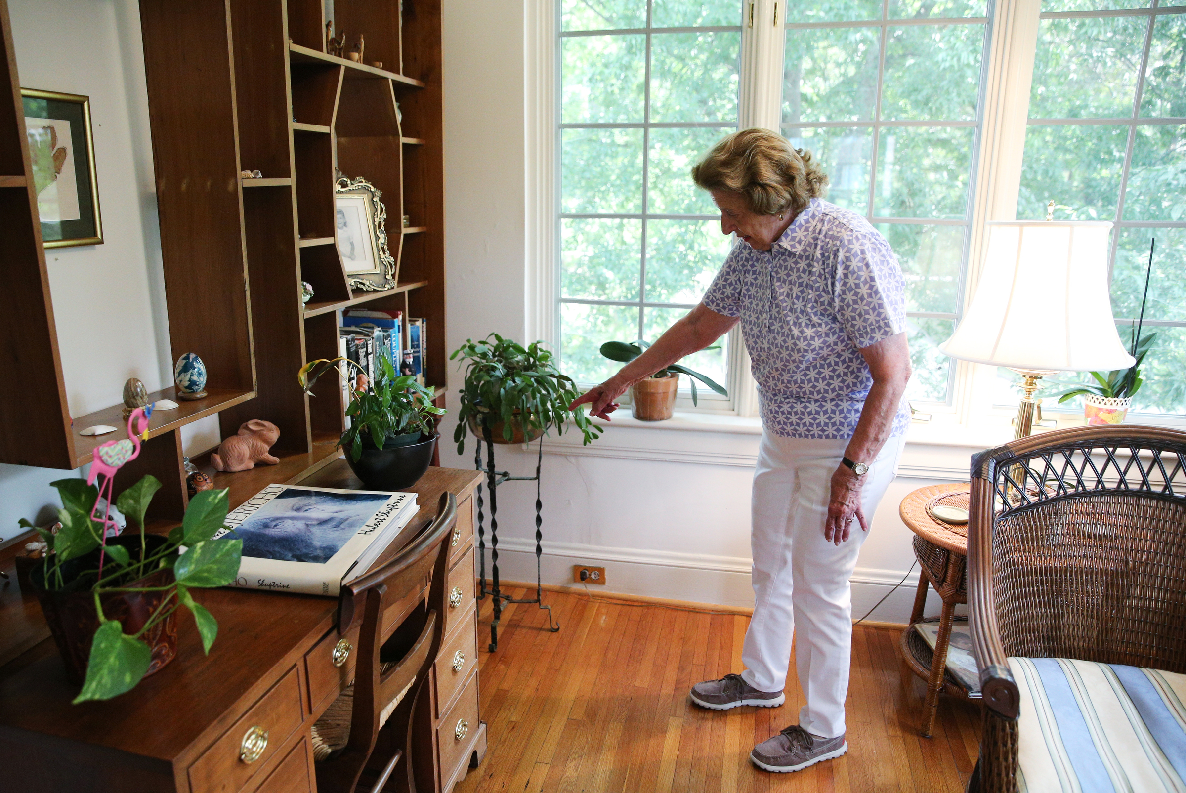 Barbara Blake points to a few of the original electrical outlets behind her bookshelf, such as a cigar lighter, that are no longer in use Wednesday, July 12, 2017, at her home on Sunset Road in Chattanooga, Tenn. The house was known as Chattanooga's Model Electric Home.