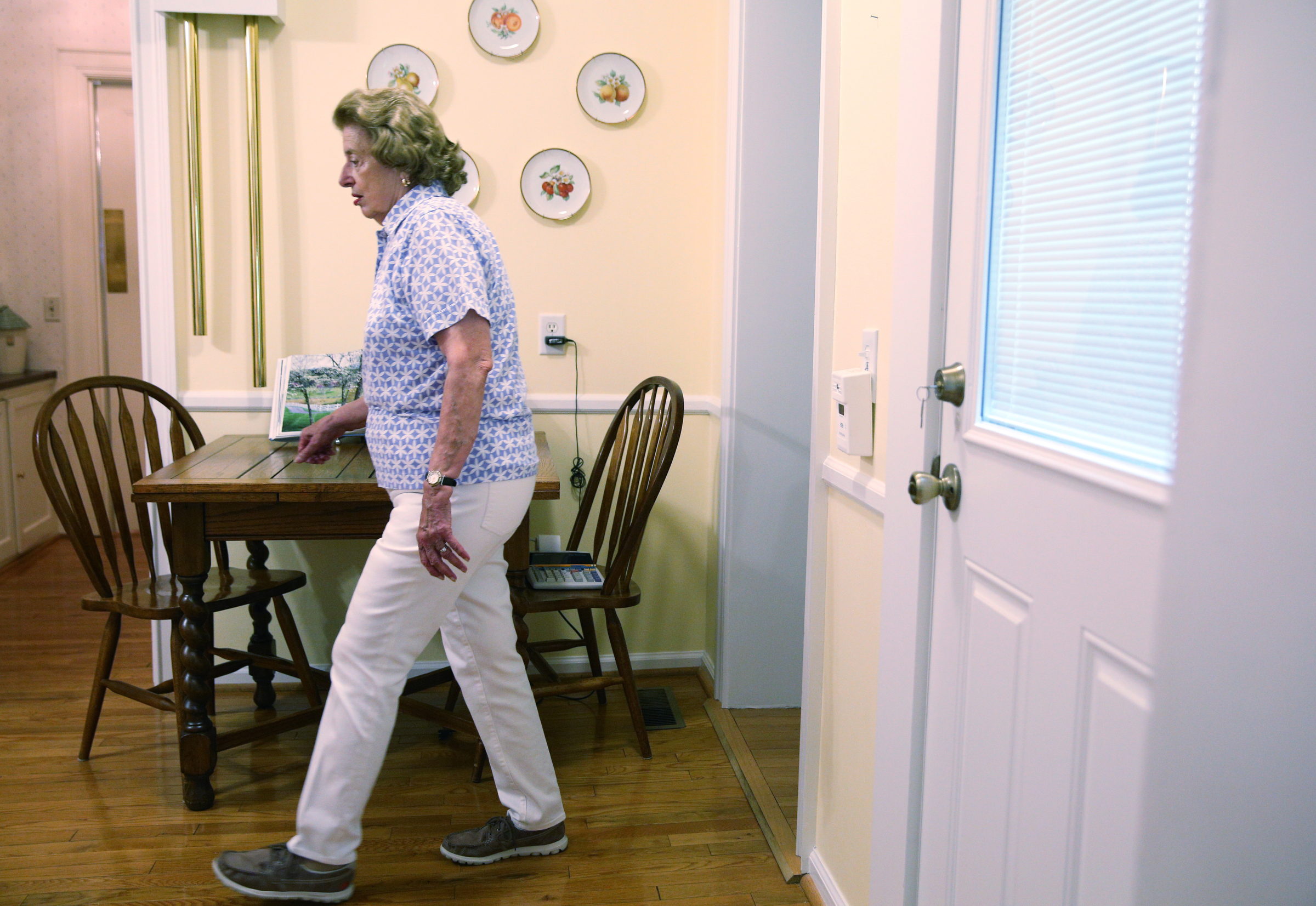 Barbara Blake walks through her kitchen to show off the original doorbell, which can be seen in the upper right, that still works Wednesday, July 12, 2017, at her home on Sunset Road in Chattanooga, Tenn. The house was built in 1925.