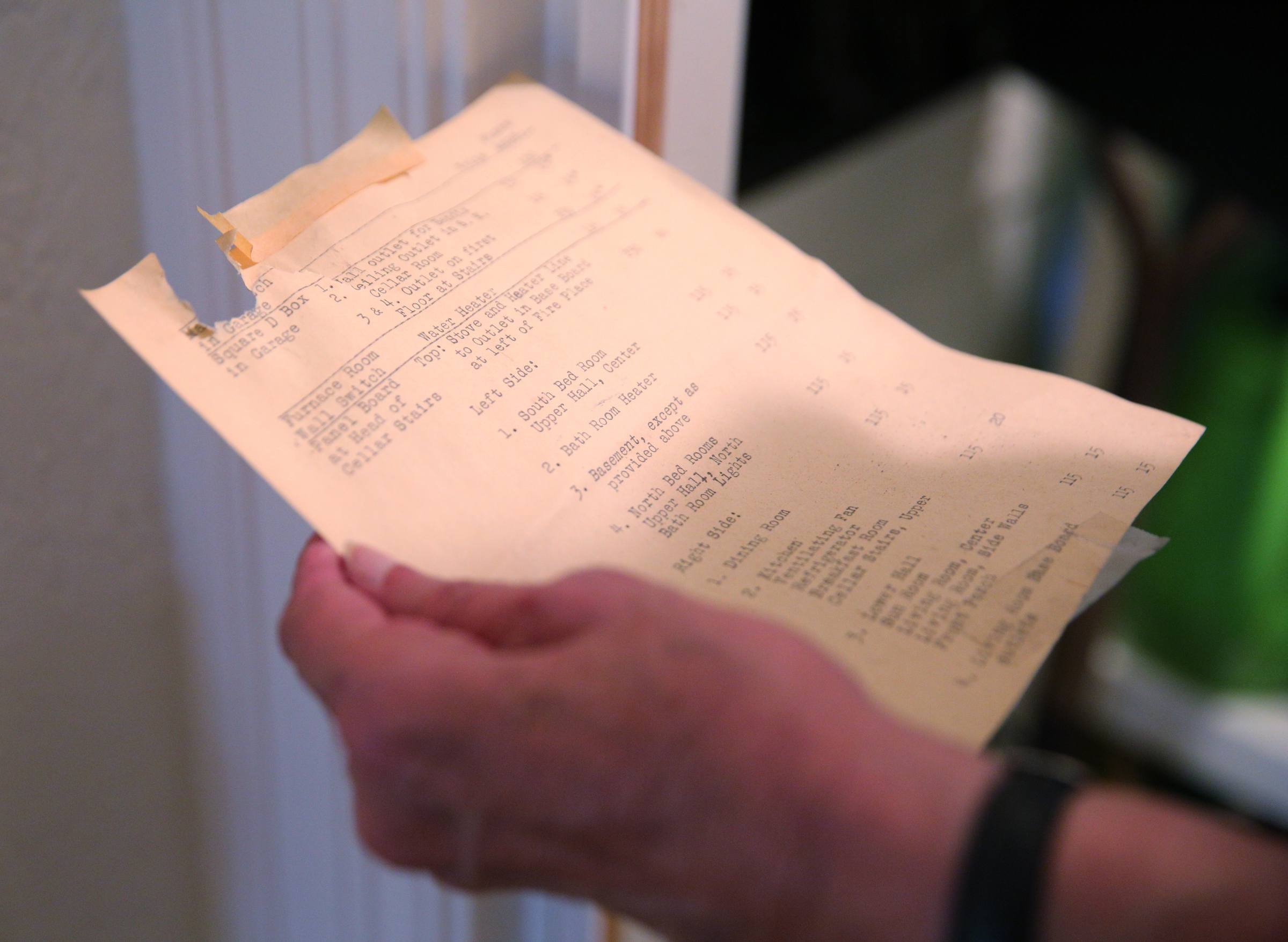 Barbara Blake pulls out a piece of paper that was in the fuse box Wednesday, July 12, 2017, at her home on Sunset Road in Chattanooga, Tenn. Parts of her fuse box are original to the house.