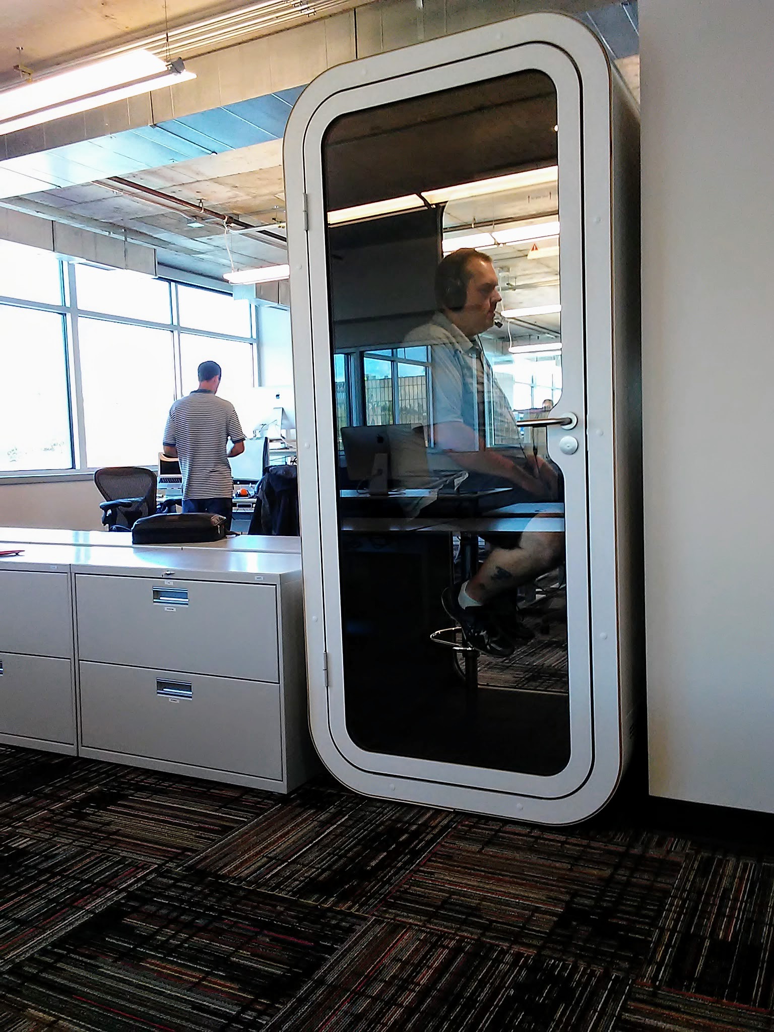 Skuid IT Solutions Engineer Justen Hollis makes a phone call inside one of a dozen Finnish phone booths that the Chattanooga software company has scattered around its three floors in Liberty Tower downtown.