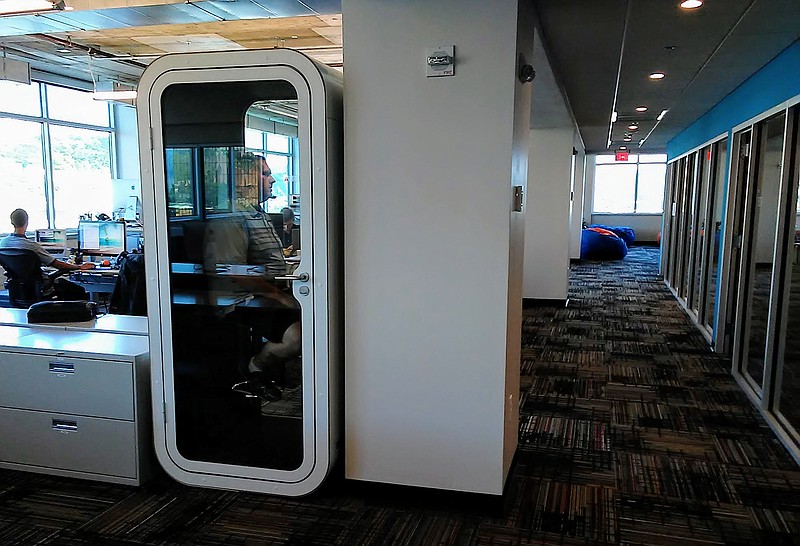 Skuid IT Solutions Engineer Justen Hollis makes a phone call inside one of a dozen Finnish phone booths that the Chattanooga software company has scattered around its three floors in Liberty Tower downtown.