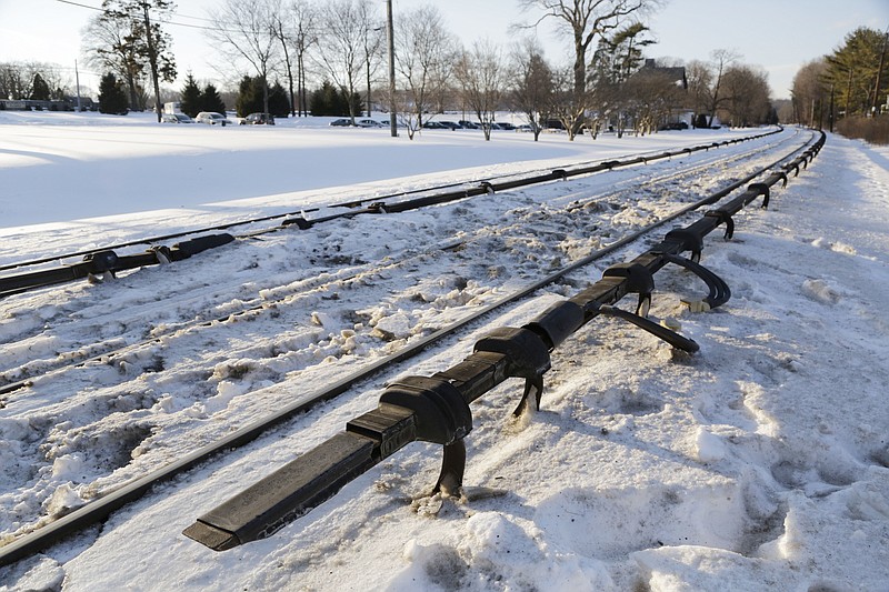 
              FILE- This Feb. 6, 2015, file photo shows the electrified third rail, bottom, that runs next to Metro-North Railroad tracks in Valhalla, N.Y. Federal investigators have concluded that a fiery crash between a commuter train and an SUV that killed six people in the suburbs in 2015 was extra deadly because of an unusual rail design, a U.S. official told The Associated Press on Monday, July 24, 2017. The rail was an under-running or under-riding design, in which a metal shoe slips underneath the electrified third rail, rather than skimming along the top. (AP Photo/Mark Lennihan, File)
            