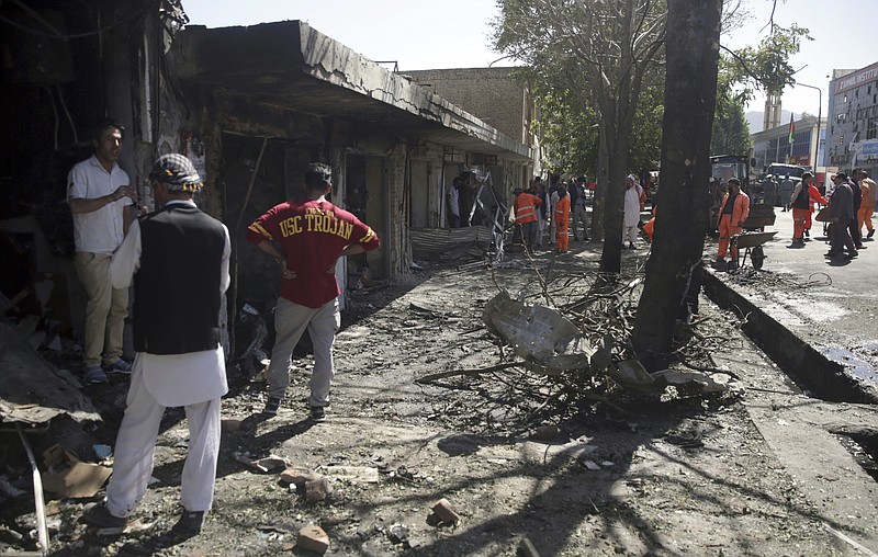 
              Men look at the remains of their properties at the site of a suicide attack in Kabul, Afghanistan, Monday, July 24, 2017. A suicide car bomb killed dozens of people as well as the bomber early Monday morning in a western neighborhood of Afghanistan's capital where several prominent politicians reside, a government official said. (AP Photos/Massoud Hossaini)
            