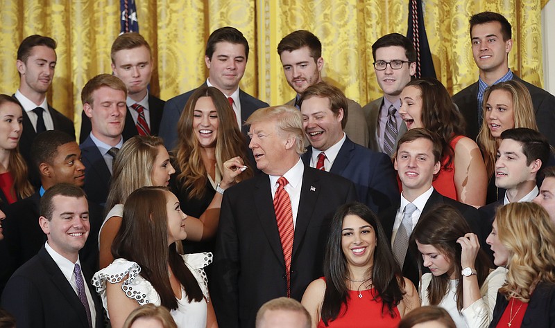 
              President Donald Trump looks over as a White House intern removes a piece of lint from as they poses for a photo in the East Room of the White House in Washington, Monday, July 24, 2017. (AP Photo/Pablo Martinez Monsivais)
            