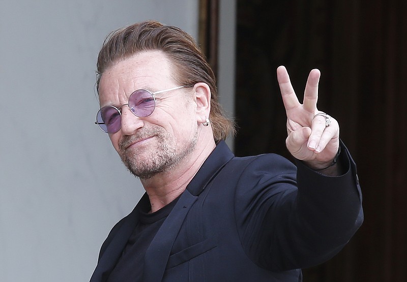 
              Founder of the non-governmental organization ONE, U2 singer Bono makes a signe as he arrives for a meeting at the Elysee Palace, in Paris, France, Monday, July 24, 2017. French President Emmanuel Macron has received pop singer and philanthropist Bono at the Elysee Palace in Paris for talks about poverty.(AP Photo/Michel Euler)
            