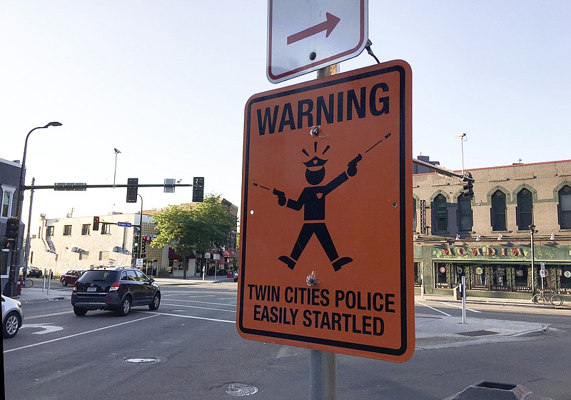 
              A fake street sign is mounted on the same pole as legitimate ones at the intersection of Cedar and Riverside Aves. Sunday, July 23, 2017, in Minneapolis. The fatal shooting of an Australian woman by a Minneapolis police officer has sparked the posting of at least two fake street signs warning people of "easily startled" officers. The Star Tribune reports the signs were spotted this weekend, one in Minneapolis and one in St. Paul. The official-looking orange metal sign reads: "WARNING: TWIN CITIES POLICE EASILY STARTLED."
(Erin Adler/Star Tribune via AP)
            