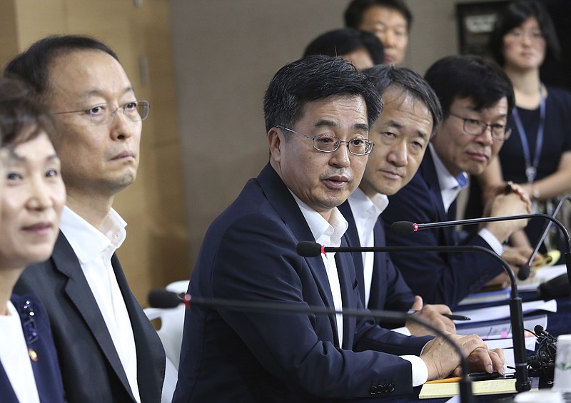 
              South Korean Finance Minister Kim Dong-yeon, center, speaks during a press conference at the government complex in Seoul, South Korea, Tuesday, July 25, 2017. South Korea's new administration is shifting gears to achieve a fair and labor-friendly economy after decades of growth led by big businesses left many behind in economic prosperity. (AP Photo/Ahn Young-joon)
            