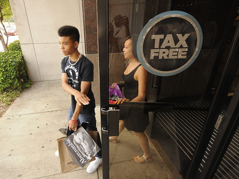 Shoppers leave Hamilton Place with bags of clothing for a new school year during a previous tax-free weekend. / Staff file photo by Tim Barber