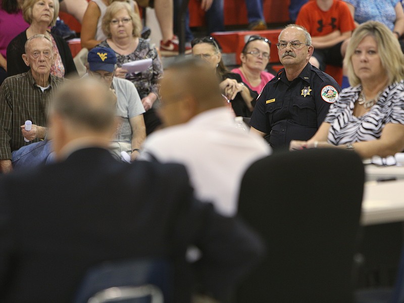 Varnell Police Chief Lyle Grant, on the right, listens as Mayor Anthony Hulsey reads a letter on behalf of a local businessman Tuesday, July 25, 2017, at the Varnell City Gym in Varnell, Ga. The Varnell City Council were meeting to decide whether or not to eliminate its police department, but there weren't enough council members in attendance for a quorum. 