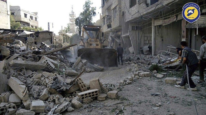 
              This photo provided by the Syrian Civil Defense White Helmets, which has been authenticated based on its contents and other AP reporting, shows citizens clearing debris in a street a day after airstrikes hit, in the Damascus suburb of Arbeen, Syria, Tuesday, July, 25, 2017. Syrian opposition activists and a paramedic group say that airstrikes in the Damascus suburb have killed several people, including children. (Syrian Civil Defense White Helmets via AP)
            