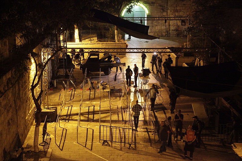 
              Israeli police officers dismantle metal detectors outside the Al Aqsa Mosque compound in Jerusalem's Old City, early Tuesday, July 25, 2017. Israel's security cabinet has decided to remove metal detectors set up at the entrance to a Jerusalem holy site which had angered Muslims. (AP Photo/Mahmoud Illean)
            