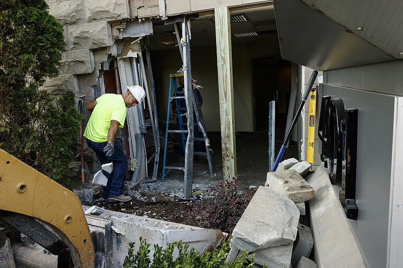 Workers repair damage to the 401 Building at 401 Chestnut St. after a Chevrolet Impala crashed into the building's side in the early morning of July 25, 2017, in Chattanooga. The driver, Paul Burton, 26, sustained minor injuries and was taken to a local hospital for evaluation. He was charged with driving under the influence, possession of drug paraphernalia, possession of a controlled substance and failure to maintain lane, according to Chattanooga Police Department public information officer Rob Simmons.