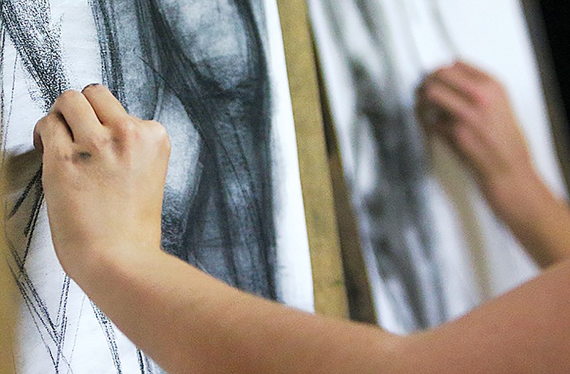 Students work on their charcoal drawings. Each week students learn a new technique.